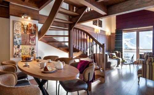 uma sala de jantar com mesa e cadeiras em Le Hameau du Kashmir em Val Thorens