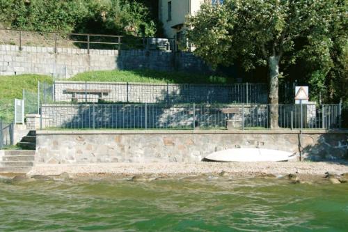 a surfboard sitting on the shore of a body of water at Antica torre del castello Casa Ceresiana in Carabietta