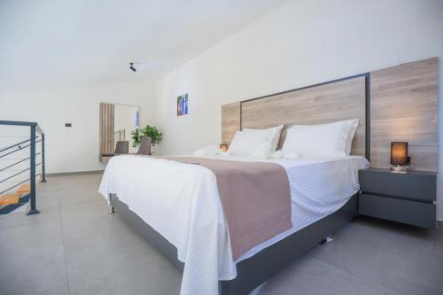 a bedroom with a large bed with a wooden headboard at Rajska dolina Budva in Budva