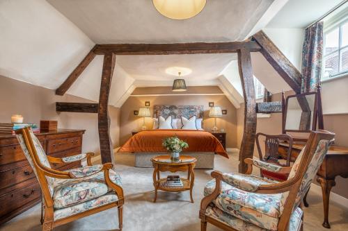 een slaapkamer met een groot bed en 2 stoelen bij Avington Estate in Winchester