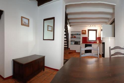 a kitchen and dining room with a table and a refrigerator at Antica torre del castello Casa Ceresiana in Carabietta