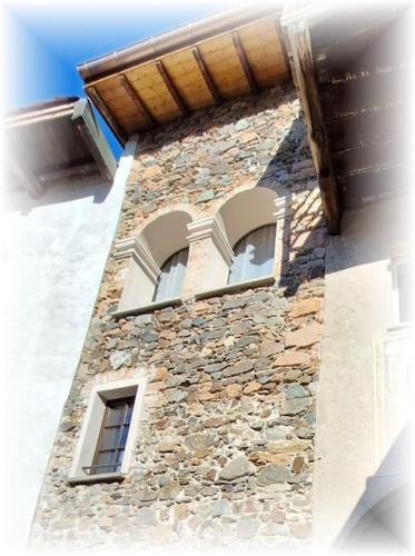 a building with two windows on the side of it at Antica torre del castello Casa Ceresiana in Carabietta
