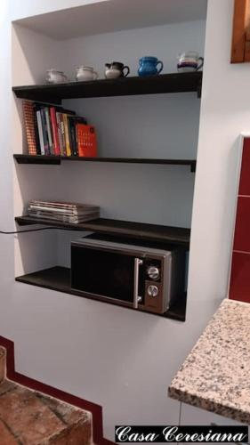 a microwave on a shelf in a kitchen at Antica torre del castello Casa Ceresiana in Carabietta