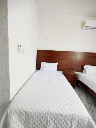 a bedroom with a large white bed in it at Departamento en tulum Quintana roo in Tulum