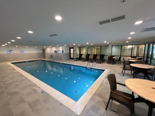 uma piscina num hotel com mesas e cadeiras em Comfort Suites Gatlinburg Downtown-Convention Center em Gatlinburg