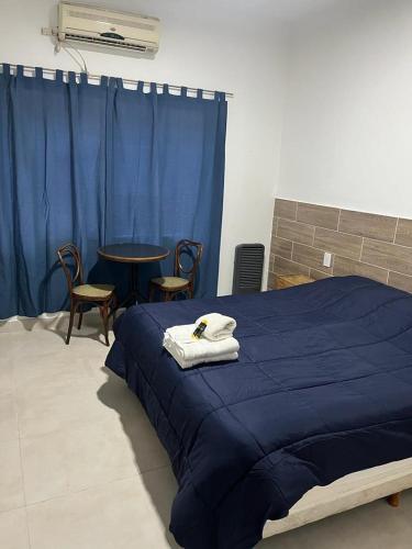 a bedroom with a blue bed with a table and chairs at Wine Aparts in Mendoza
