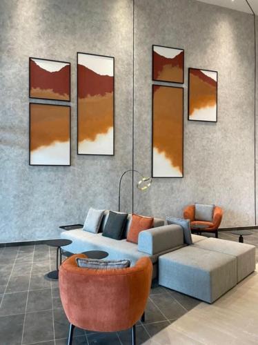 a living room with a couch and some chairs at MUJI Cosy Level 25th Room Amber Residence @ Quayside Mall Rimbayu Near to Masha Oasis Tenby KLIA Kota Kemuning in Teluk Panglima Garang
