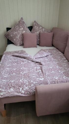 ein Bett mit einer rosa Bettdecke und Kissen darauf in der Unterkunft Cosy Appartement Zentral in Köln