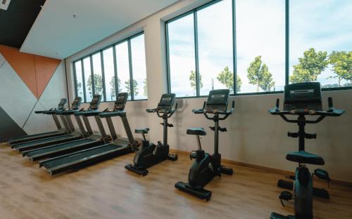 a gym with treadmills and ellipticals in a room with windows at MUJI Cosy Level 25th Room Amber Residence @ Quayside Mall Rimbayu Near to Masha Oasis Tenby KLIA Kota Kemuning in Teluk Panglima Garang