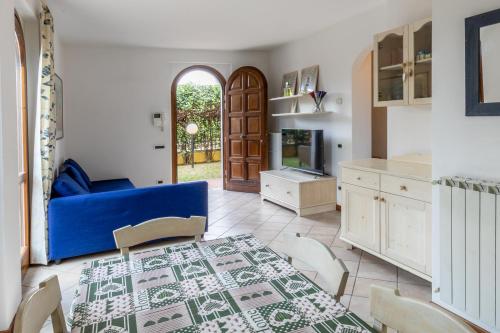 a living room with a blue couch and a table at Villa vicino al mare con giardino e parcheggio in Cinquale