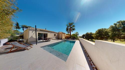 カップ・ダグドにあるCap d'agde Maison sur le golf avec piscine chauffée.の家の前のスイミングプール