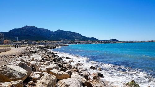 a group of rocks on a beach with the ocean at maison plages et calanques 6 personnes in Marseille