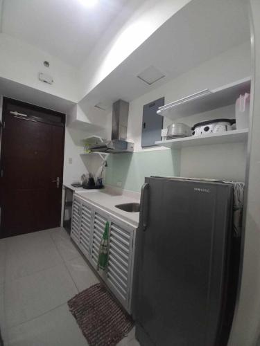 a small kitchen with a sink and a refrigerator at Beach condos at Pico de Loro Cove - Wi-Fi & Netflix, 42-50''TVs with Cignal cable, Uratex beds & pillows, equipped kitchen, balcony, parking - guest registration fee is not included in Nasugbu