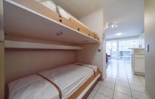 a bedroom with two bunk beds and a kitchen at Studio Sia - Lichtrijke studio met balkon met zijzeezicht in hartje de Panne in De Panne