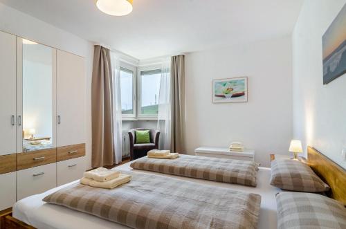 1 Schlafzimmer mit 2 Betten und einem Stuhl in der Unterkunft Ferienwohnung Alex in Meersburg