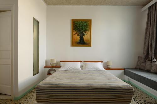 a bedroom with a bed and a painting on the wall at Vallas Apartments & Villas in Firostefani