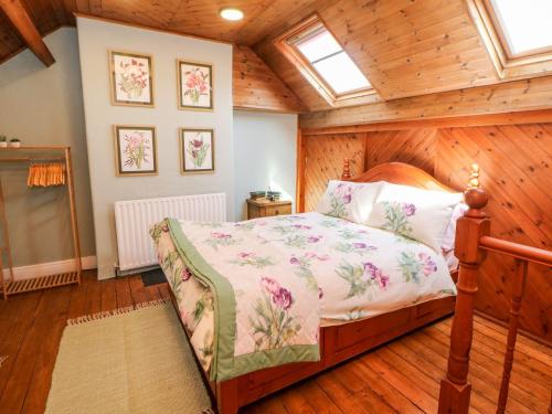 a bedroom with a bed in a room with wooden walls at Waters Edge in Bakewell