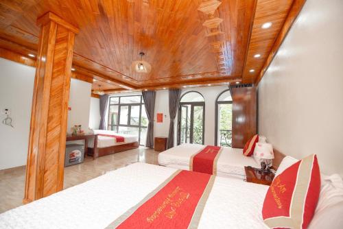 a bedroom with two beds and a wooden ceiling at TRANG AN LUXURY HOMESTAY in Ninh Binh