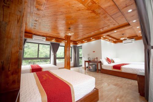 a bedroom with two beds and a wooden ceiling at TRANG AN LUXURY HOMESTAY in Ninh Binh