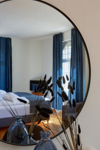 a mirror on a table in a bedroom with a bed at Hotel Schiff am See in Murten