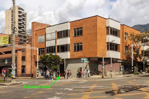 a building on a street corner with a group of people at Center City Flats - Apartments in El Poblado near Park Lleras, Medellin! in Medellín