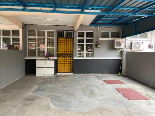 a large kitchen with a yellow door in a room at IBRAHIM’S HOMESTAY in Kuala Kerai