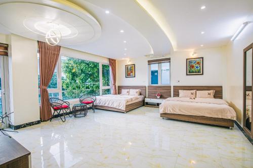 sypialnia z 2 łóżkami, stołem i krzesłami w obiekcie Mai Linh Villa - FLC Sam Son w mieście Sam Son