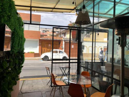 a glass table and chairs in front of a street at Puruha Inn in Riobamba