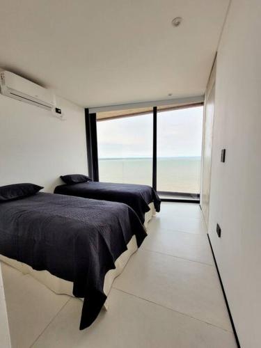 - 2 lits dans une chambre avec une grande fenêtre dans l'établissement Ará Yasy, à Posadas