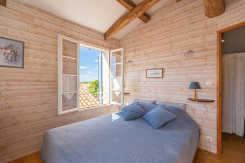 une chambre avec un lit et une fenêtre dans l'établissement Isatis, à Mortagne-sur-Gironde