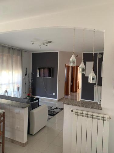 uma cozinha e sala de estar com um sofá e uma mesa em Casa vacanza Valledoria 2 camere da letto em Valledoria