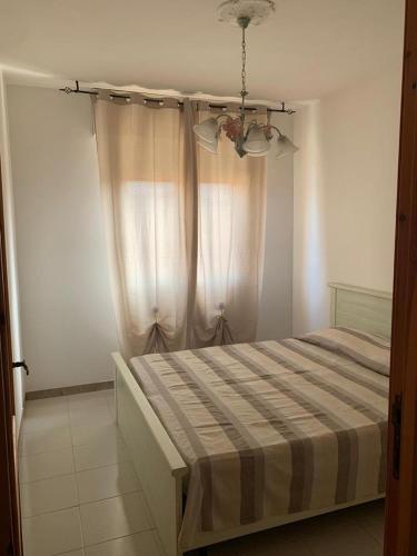 um quarto com uma cama com um cobertor listrado em Casa vacanza Valledoria 2 camere da letto em Valledoria