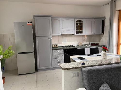 uma cozinha com armários brancos e um frigorífico em Casa vacanza Valledoria 2 camere da letto em Valledoria