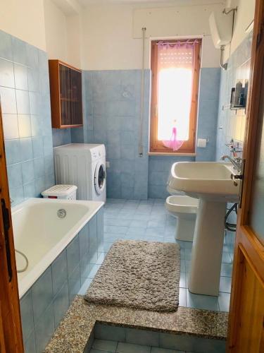 uma casa de banho com uma banheira branca e um lavatório. em Casa vacanza Valledoria 2 camere da letto em Valledoria
