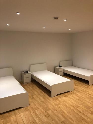 two beds in a room with wooden floors at Möbilierte 3 Zimmer Wohnung mit großer Wohnküche in Dossenheim