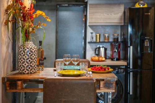 - une table avec des verres à vin et un bol de fruits dans l'établissement Le Loft - Un Voyage Urbain au Coeur de la Ville, à Nice