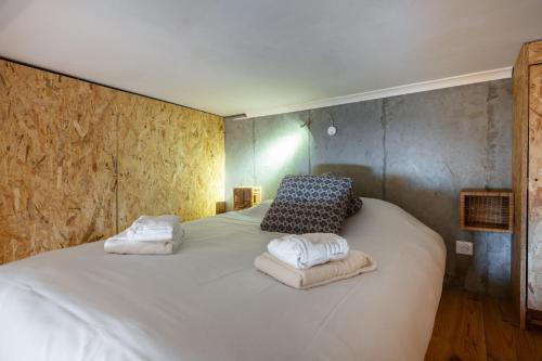 une chambre avec un grand lit blanc avec deux oreillers dans l'établissement Le Loft - Un Voyage Urbain au Coeur de la Ville, à Nice