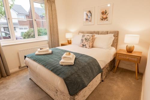 a bedroom with a bed with two towels on it at Great 4 bedroom home with garden on the Wirral Peninsula in Birkenhead