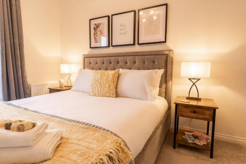 a bedroom with a bed with two lamps and two tables at Great 4 bedroom home with garden on the Wirral Peninsula in Birkenhead