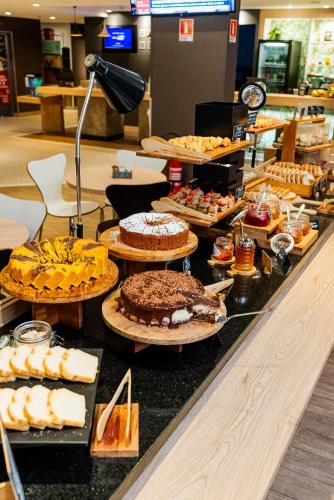 a buffet with many different types of cakes and pastries at ibis Porto Alegre Moinhos de Vento in Porto Alegre