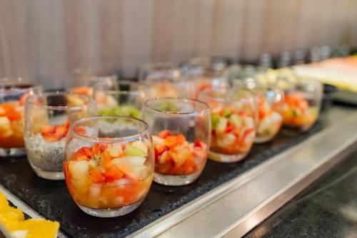 a row of cups filled with food on a counter at ibis Porto Alegre Moinhos de Vento in Porto Alegre