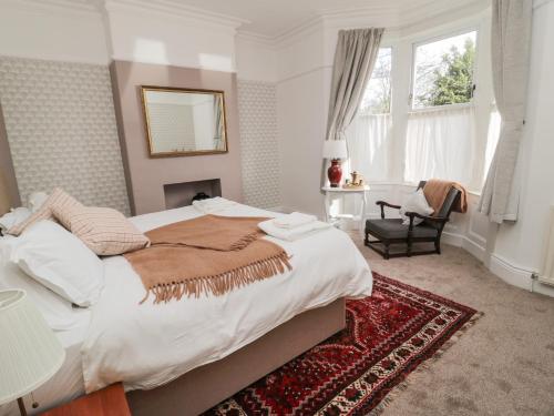 een slaapkamer met een groot bed en een stoel bij Limpet Lodge in North Shields