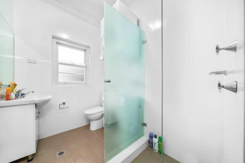 a bathroom with a shower and a sink and a toilet at Harbour Bridge View 2BR Resort in Sydney