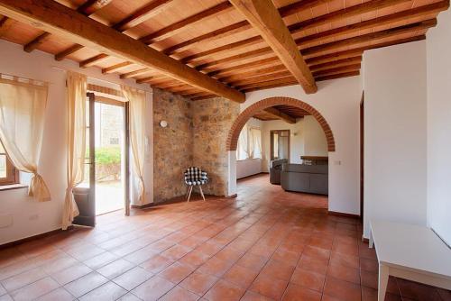 una gran sala de estar con una pared de ladrillo y techos de madera. en La Limonaia - I Borghi Della Selvaccia en Cennina