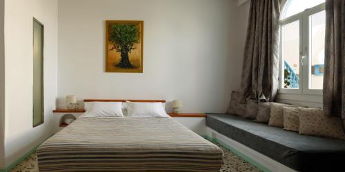 a bedroom with a bed and a window at Vallas Apartments & Villas in Firostefani