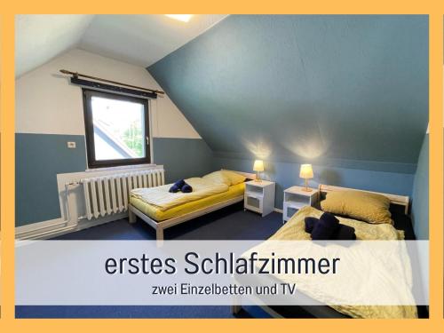 um quarto no sótão com 2 camas e uma janela em Attraktives Ferienhaus im Grünen em Falkensee