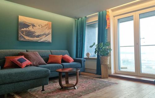 a living room with a blue couch and a table at Descente à la mer in Boulogne-sur-Mer