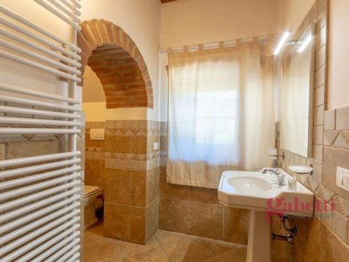 bagno con lavandino, servizi igienici e finestra di La Loggia - I Borghi Della Selvaccia a Cennina