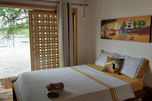 a bedroom with a bed with a hat on it at Casa Mari - ilha de Algodoal in Algodoal