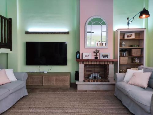 a living room with two couches and a flat screen tv at Alojamiento entero G&G con piscina in Bareyo